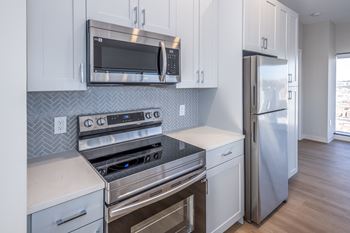 A kitchen with a stove top oven, microwave, and refrigerator.